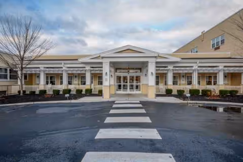 Front view of a senior living facility entrance with a covered walkway