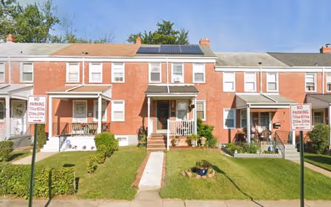 Exterior view of Golden Age Inn, row of brick townhouses with stairs and green lawns.