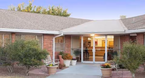 The front entrance of Casa Del Sol Center features a brick exterior and potted plants.