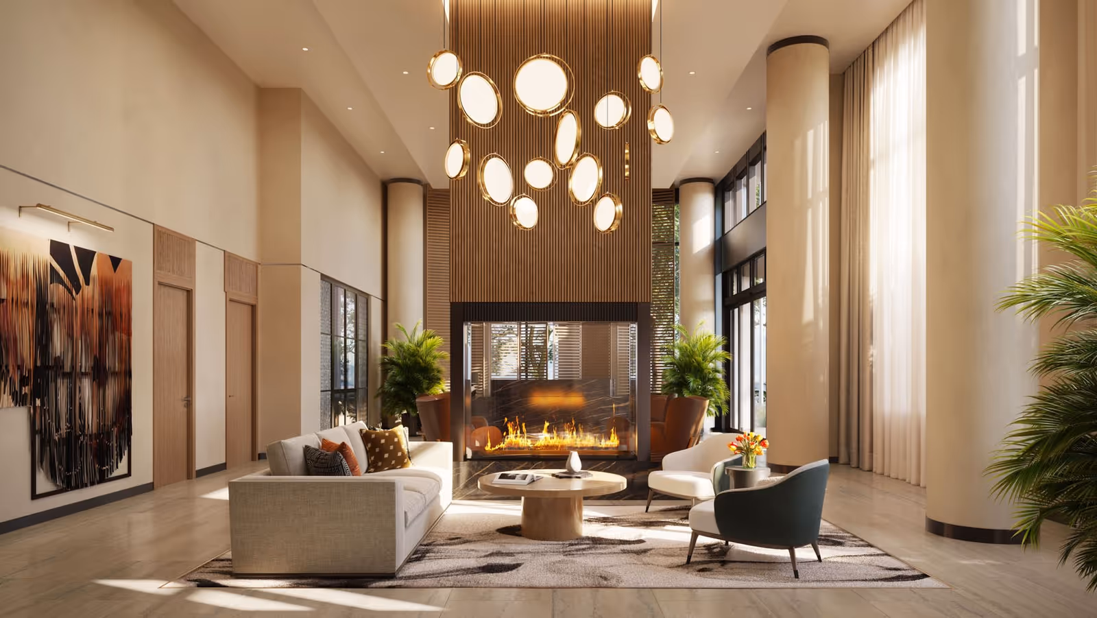 Bright upscale lounge with sofas and chairs arranged around a central fireplace beneath a modern chandelier.