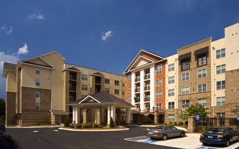 Exterior view of Oasis at Scholars Landing, a multi-story senior living facility with entrance canopy.