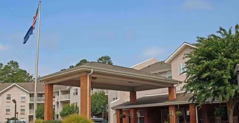 Exterior view of Holiday Columbia Pines with a covered entrance and flagpole.