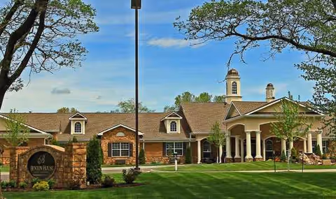 Exterior view of Addington Place of Prairie Village with a stone sign and green lawn.