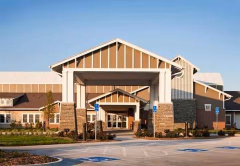 Front view of a senior living facility entrance with a covered porte-cochère.