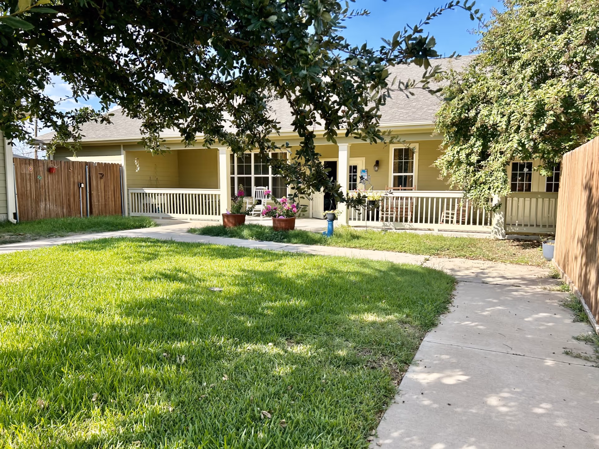 Single-story building with a covered front porch, white railing, and a grassy yard.