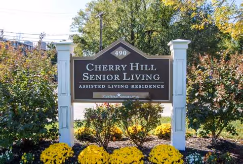 Outdoor view of Cherry Hill Senior Living sign surrounded by landscaping.