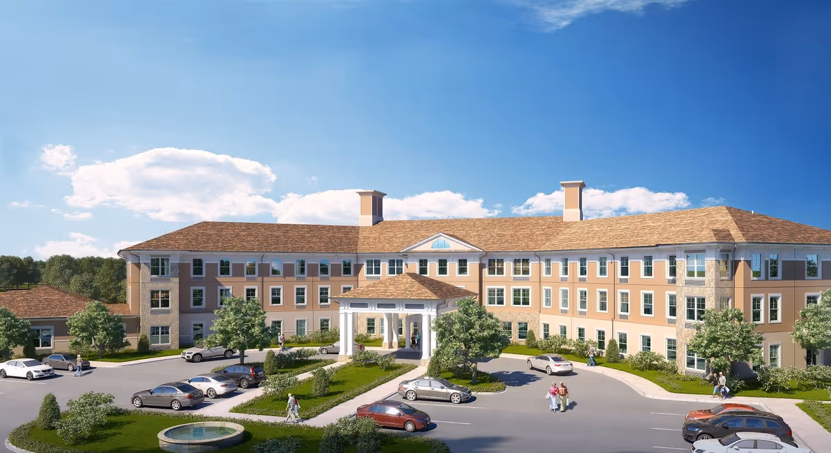 Three-story senior living building with a covered main entrance, parking lot, landscaped grounds, and a few people near the entrance.