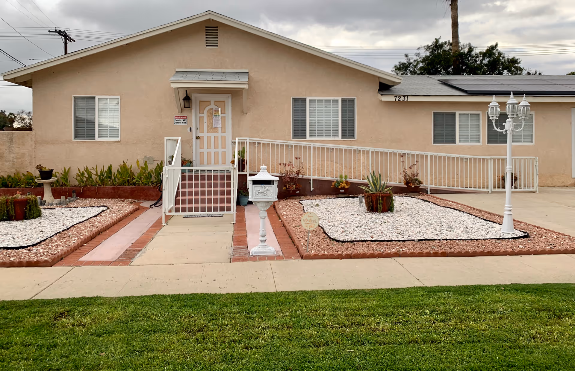 Exterior view of the Precious Moments senior living facility with landscaping and a ramp.