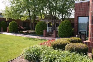 Exterior view of Nhc Healthcare - Anderson with brick building, trimmed shrubs, and manicured lawn.
