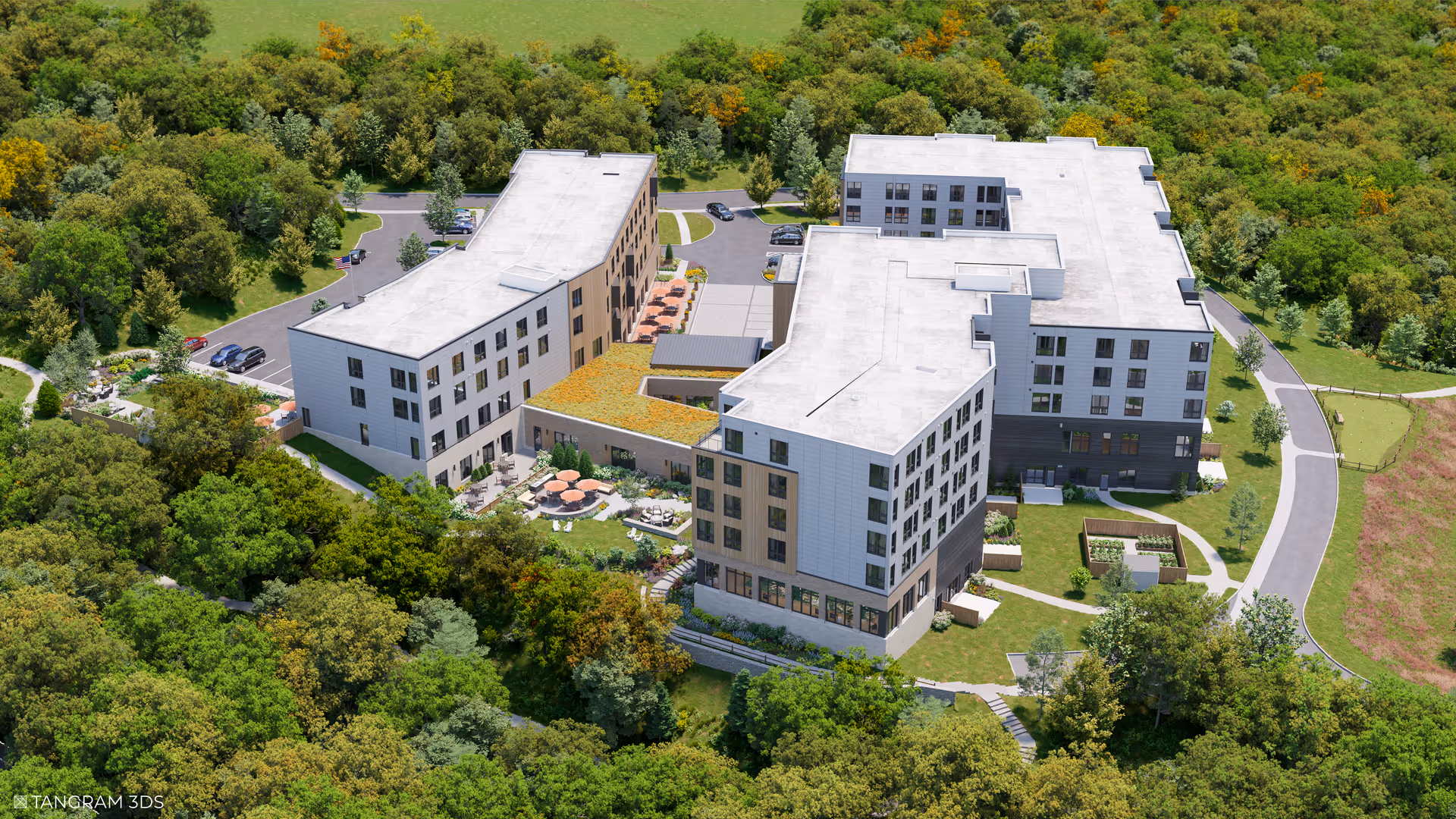 Aerial view of a modern senior living facility named Waterstone of Lexington surrounded by dense green trees and landscaped grounds. The building has multiple wings with flat white roofs, outdoor seating areas with tables and umbrellas, parking spaces, and walking paths around the property.