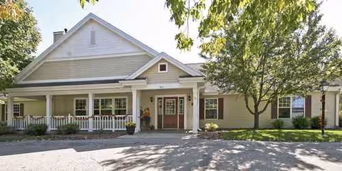 Single-story senior living facility with a covered front porch and landscaped entrance.