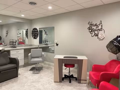 A bright interior salon area with styling chairs, a manicure table, mirrors, and wall decor reading 'Have A Beautiful Day'.