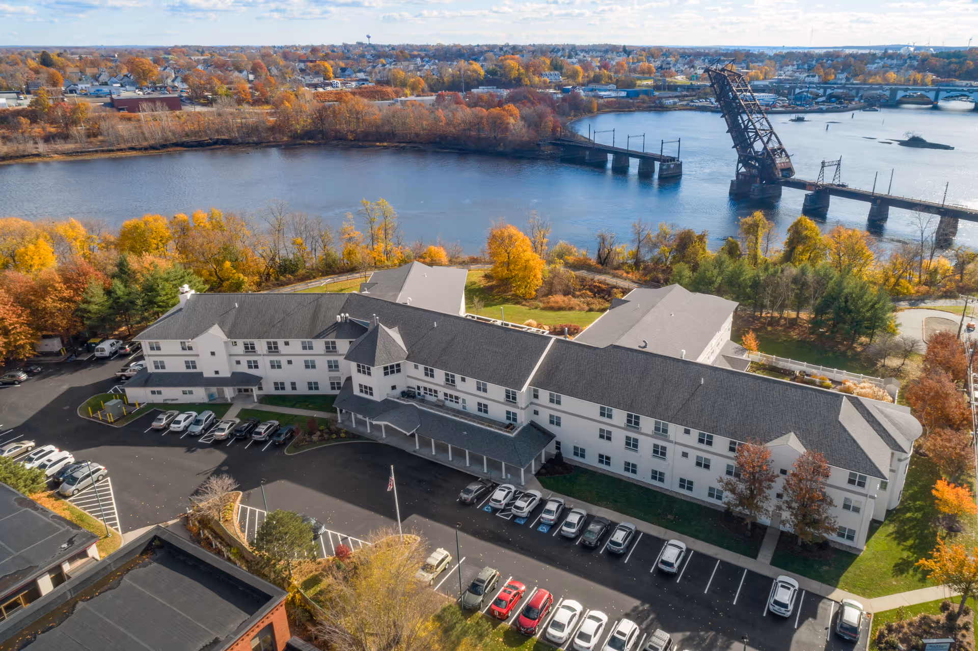 Aerial view of Wingate Residences on the East Side, showcasing the building and surrounding landscape near a river.