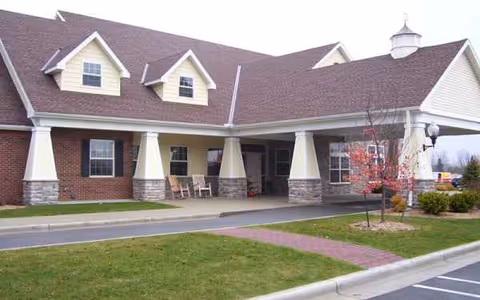 Front view of a senior living facility with a covered entrance and brick exterior.