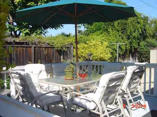 Outdoor patio at Remmington Place with a table, chairs, and a large umbrella.