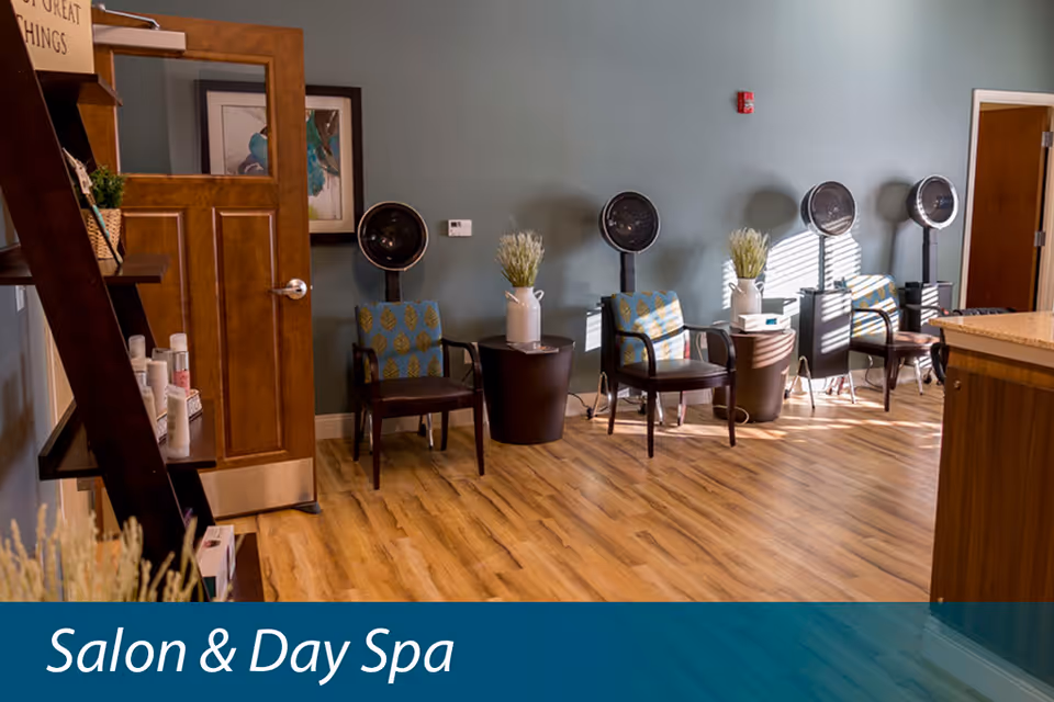 A salon interior showing several styling chairs with hooded hair dryers against a teal wall and a 'Salon & Day Spa' banner.