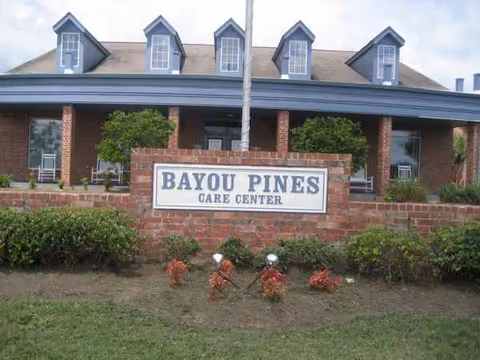 Exterior view of Bayou Pines Care Center with brick facade and a sign.