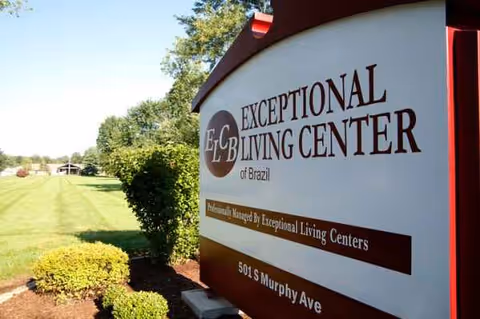 Exterior sign for Exceptional Living Center of Brazil with manicured lawn nearby.