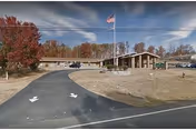 Exterior view of Jefferson Park at Dandridge: curved driveway, flagpole, and autumn trees.