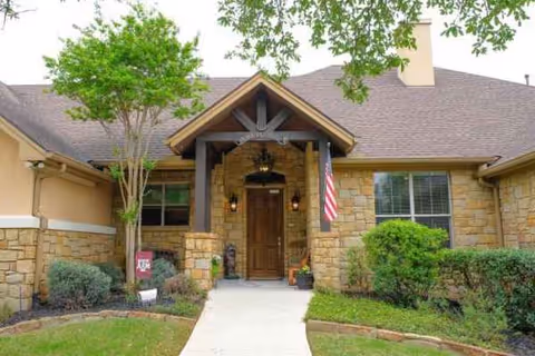 Tiffin House senior living center with a wooden entry porch and flag.