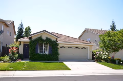 Front view of a single-story home with a two-car garage and green lawn.