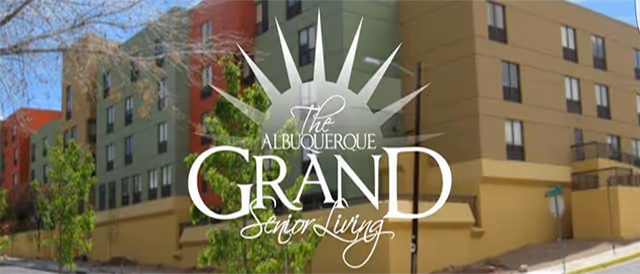 Exterior view of a colorful multi-story senior living building with Albuquerque Grand Senior Living branding.