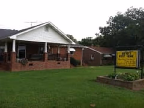 Front view of Boyd's Rest Home, brick building with a yard sign.