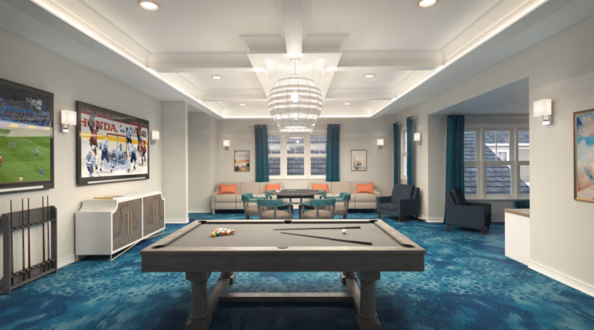 A spacious recreational room with a pool table in the center, two wall-mounted televisions showing sports, a seating area with sofas and chairs, blue patterned carpet, and large windows with blue curtains.