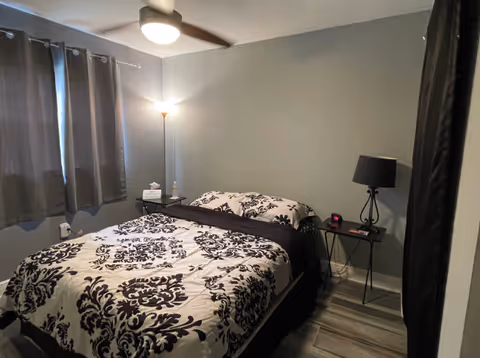 Two twin beds with black-and-white floral bedding in a small shared bedroom.