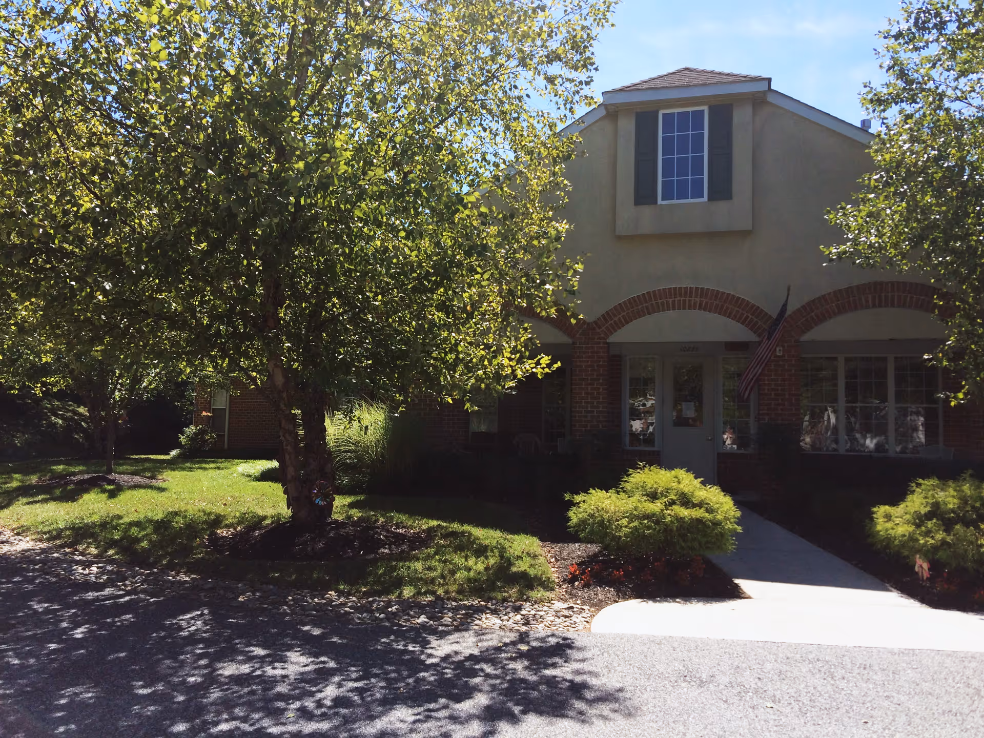 Exterior view of Greenfield Senior Living at Cockeysville with trees and landscaping.