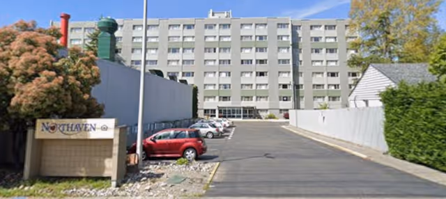 Front view of a multi-story senior living building with a parking lot and a 'Northaven' sign.