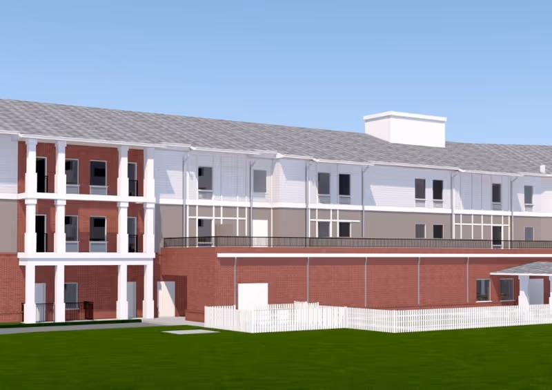 Exterior view of Sunflower Springs at Lake Wylie, brick and white siding building on green lawn.