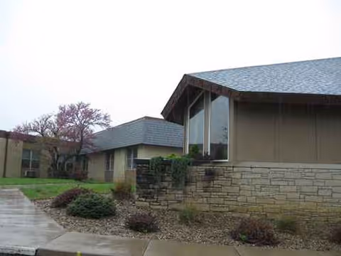 Exterior view of a Medicalodges Jackson County facility, low-slung building with stone accents and landscaping.