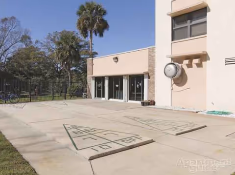 Exterior view of Mount Carmel Gardens with entrance doors and paved outdoor area.