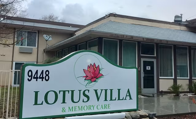 Front entrance of Lotus Villa & Memory Care with a large sign showing the name, address 9448, and a lotus logo.