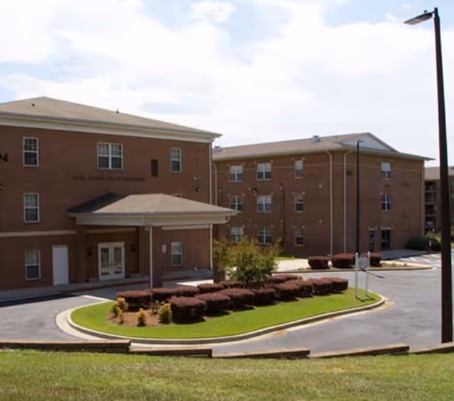 Exterior view of Magnolia Manor showing the building entrance and surrounding landscaping.