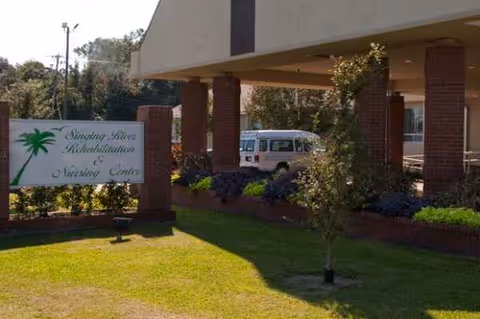 Exterior view of Diversicare of Moss Point entrance with sign and van.