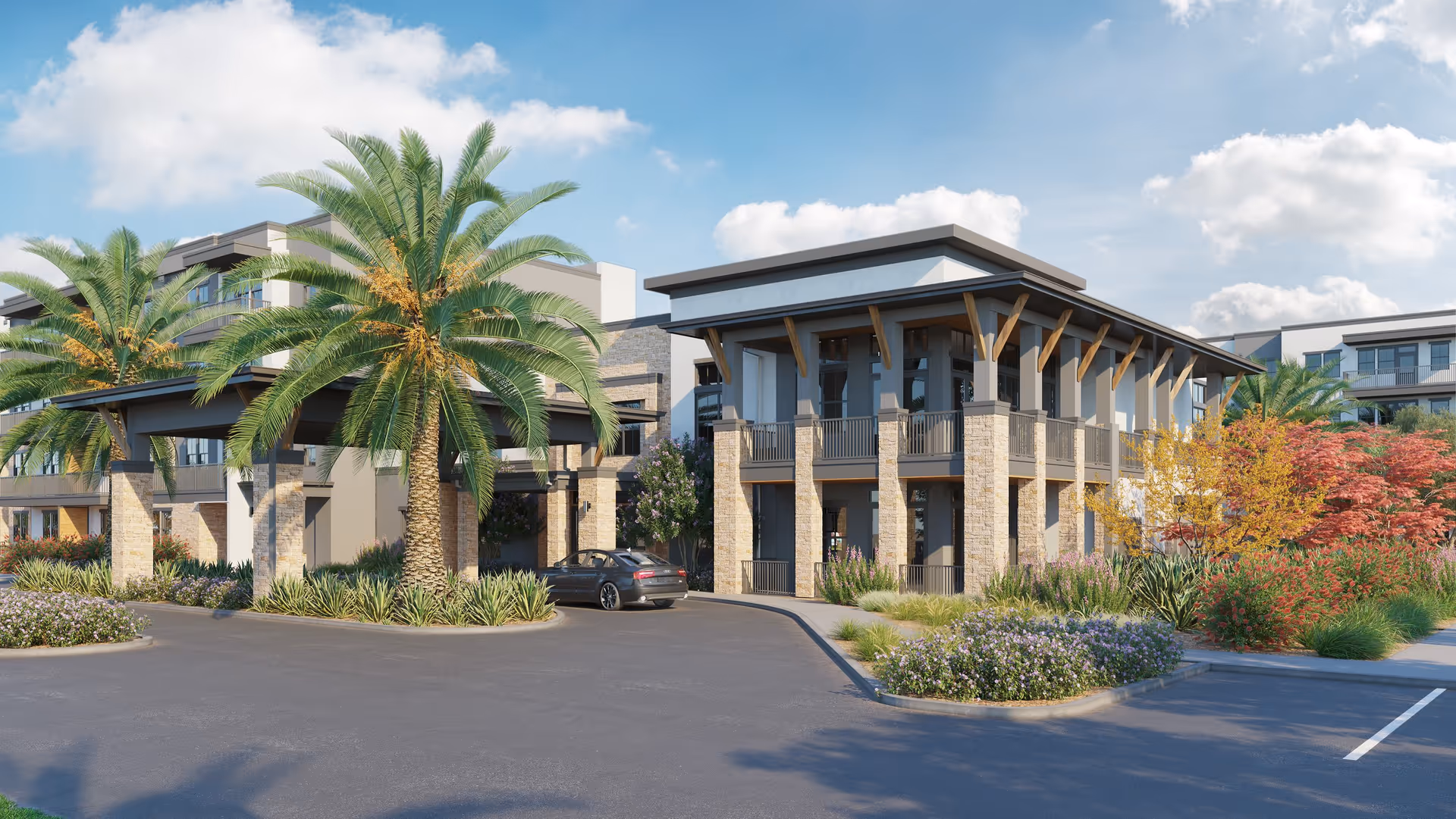 Modern two-story building front with a covered entrance, palm trees, landscaped grounds and a driveway with a parked car.