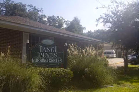 Front exterior of Tangi Pines Nursing Center with sign, landscaping, and parked vehicles.