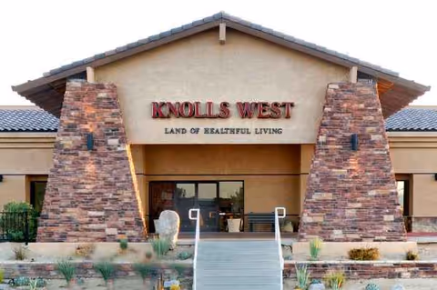 Front entrance of Knolls West Residential Care with stone pillars and stairs.