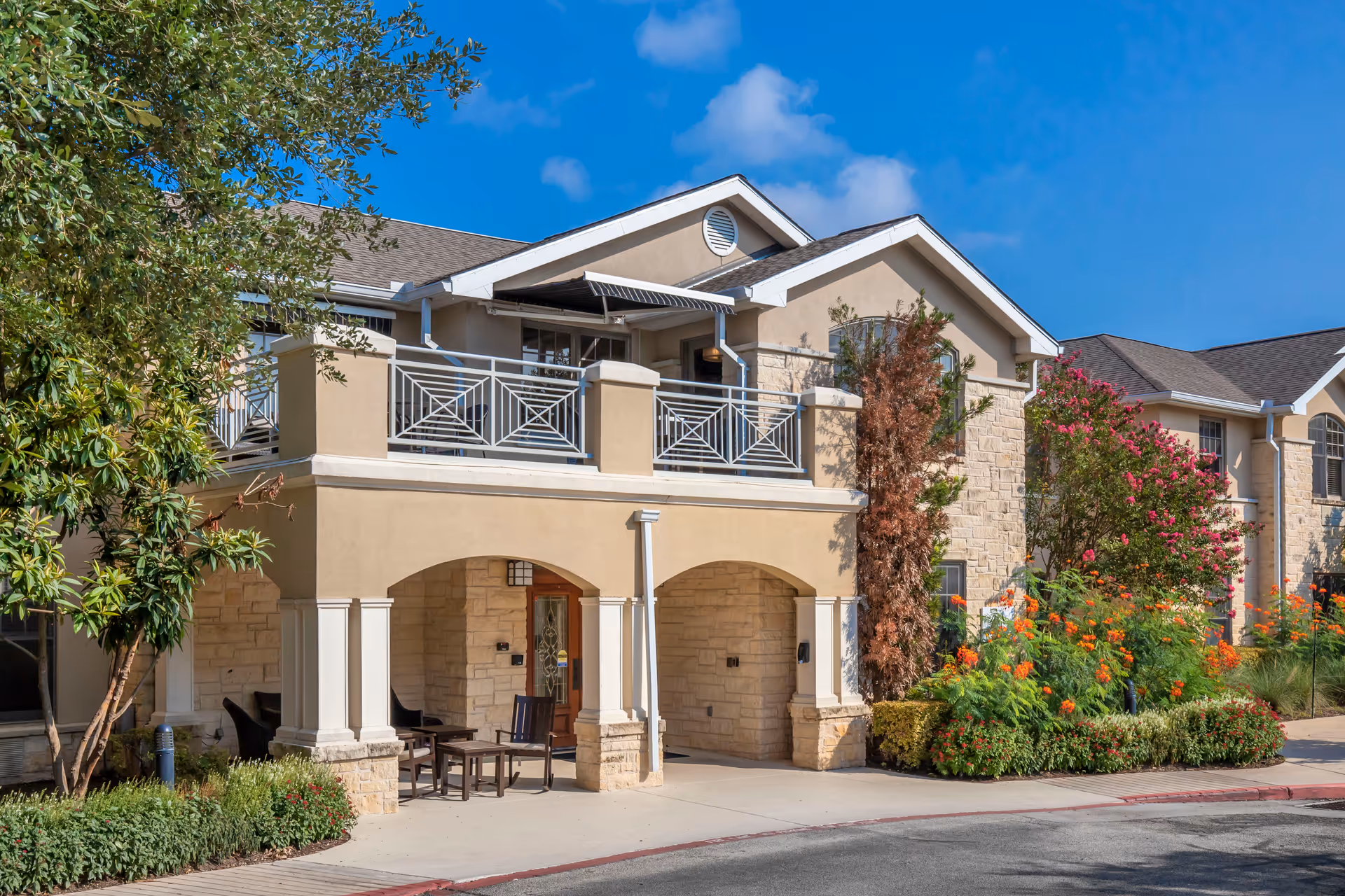 Brookdale Lakeway exterior: beige building with balcony, arches, and lush landscaping.