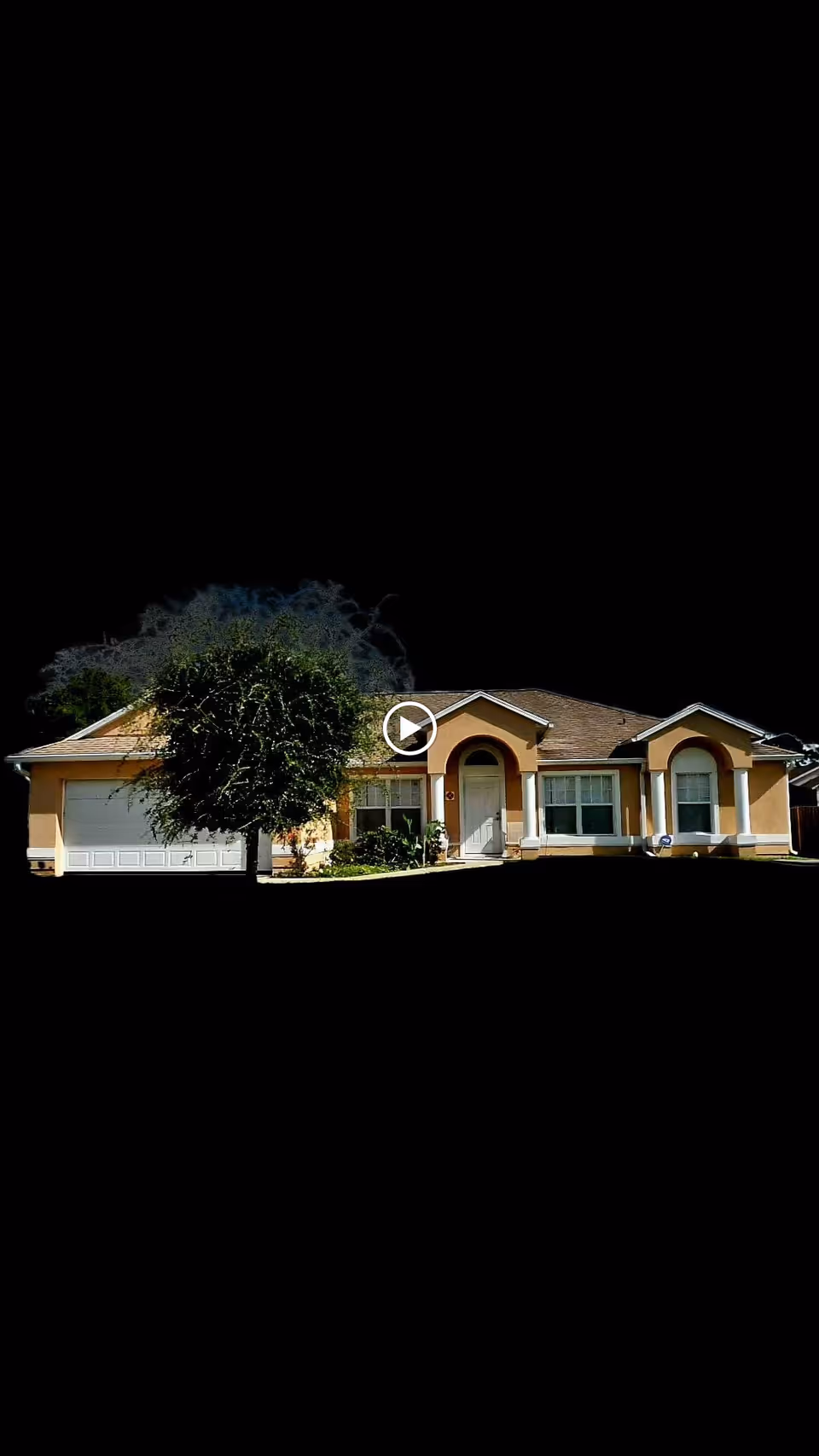 Single-story stucco house with an attached garage, front porch, and a tree on the lawn against a black background.