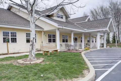 Exterior view of Chandler Place senior living facility with a covered entrance and parking.