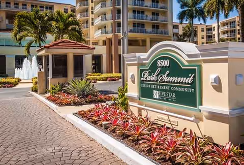 Entrance sign for Park Summit Senior Retirement Community with landscaped front courtyard and palms