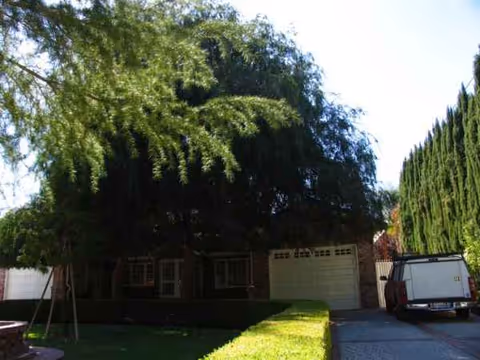 Single-story brick facility exterior with a two-car garage and shaded front yard.