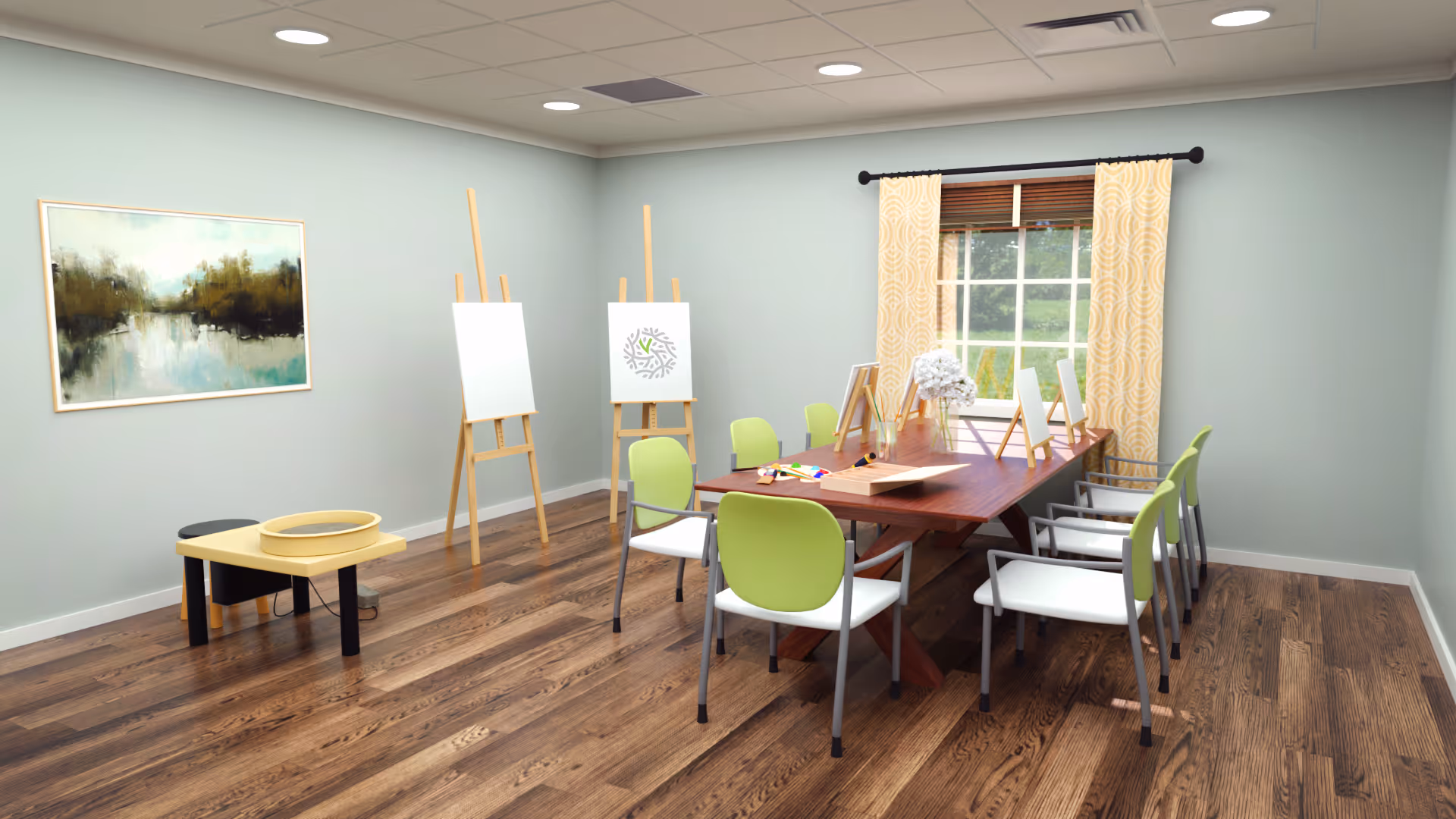 Bright activity room with a long wooden table surrounded by green-and-white chairs, easels, and a window with yellow curtains.