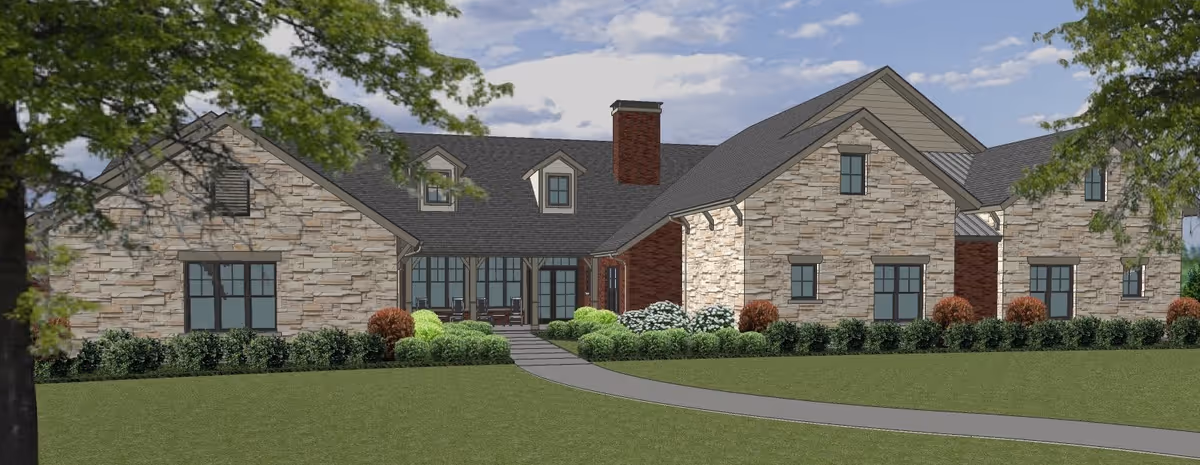 Exterior view of a single-story assisted living facility building with stone and brick facade, multiple windows, a central chimney, and a pathway leading to the entrance surrounded by green shrubs and trees under a partly cloudy sky.