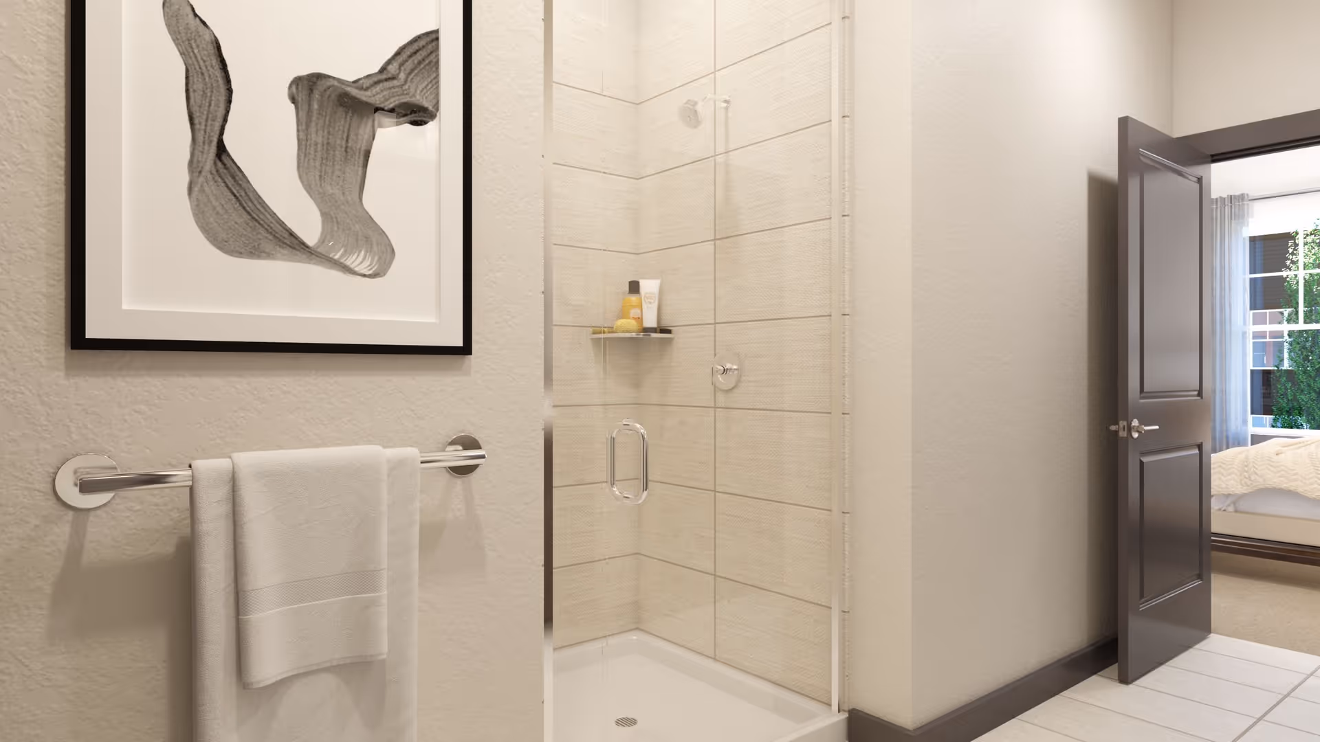 A modern bathroom with a glass-enclosed shower featuring beige tiles and a small shelf holding toiletries. A white towel hangs on a chrome towel bar mounted on a textured beige wall, which also displays a framed abstract black and white artwork. An open door reveals a glimpse of a bedroom with a bed and a window with curtains.