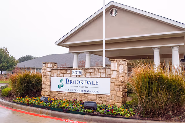 Exterior view of Brookdale Oak Hollow entrance with stone signage and landscaping.