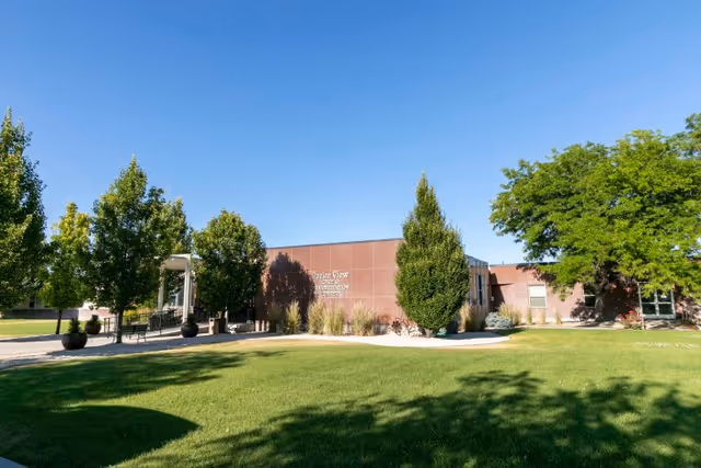 Front exterior of Parke View Rehabilitation & Care Center with a manicured lawn, trees, and a walkway.